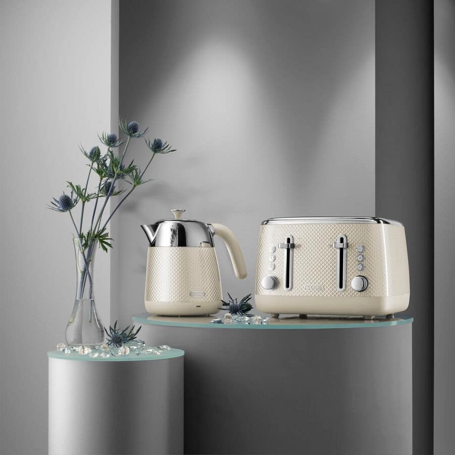 Cream-colored kettle and toaster on a glass shelf 