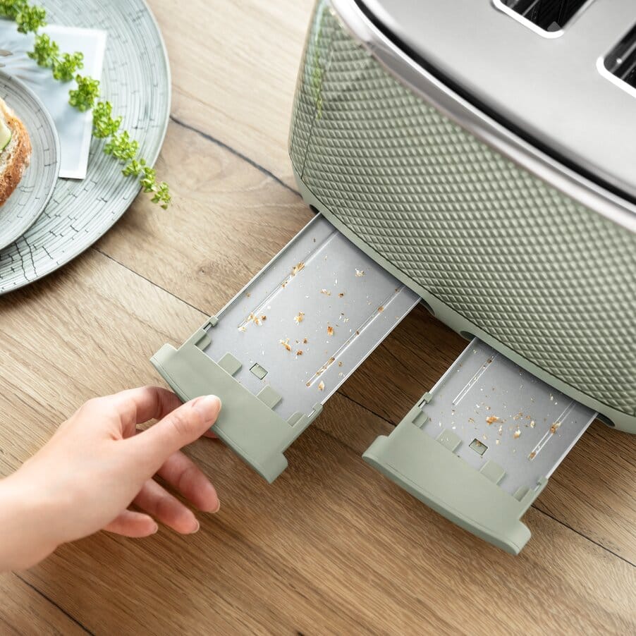 Hand opening a green kitchen appliance drawer 