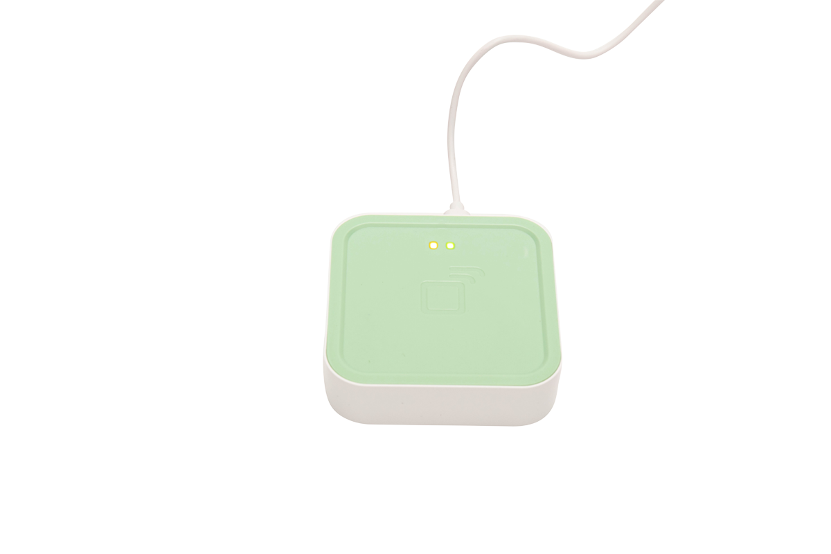 Light green electronic device with a white cable on a white background