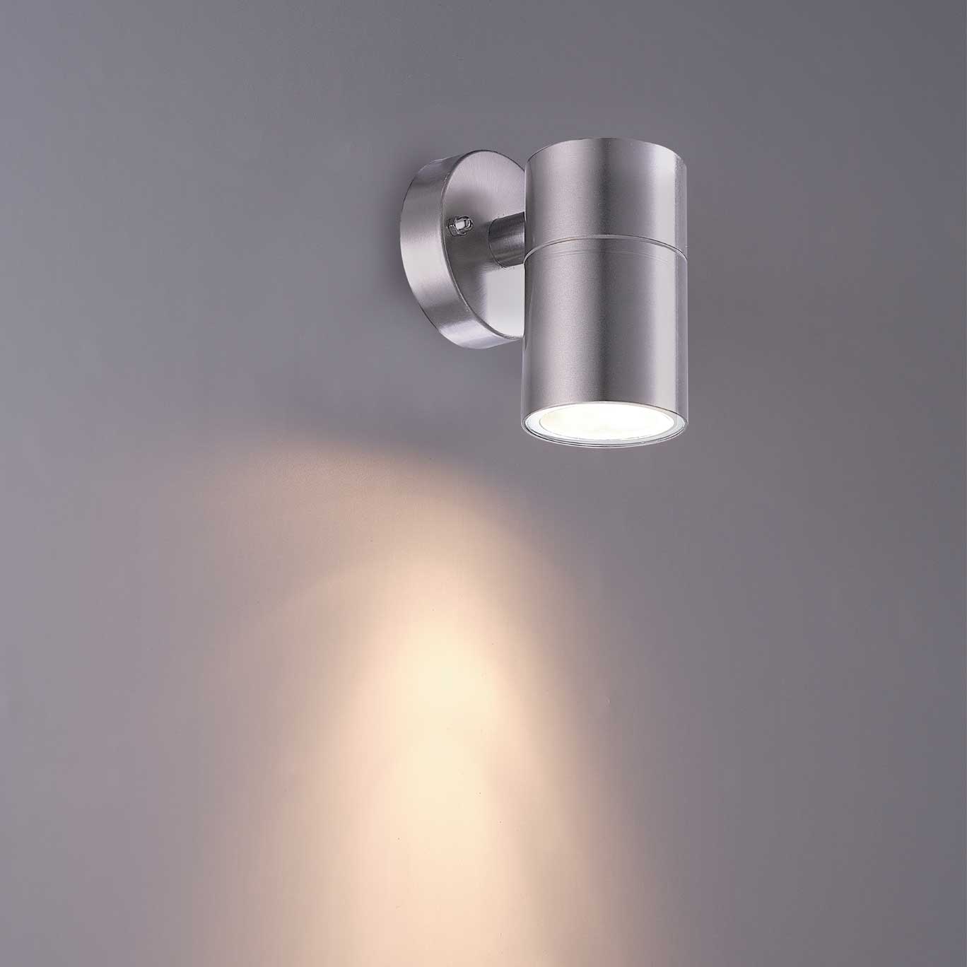 Metallic wall-mounted light fixture on a gray background