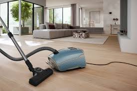 Vacuum cleaner on a wooden floor in a modern living room.