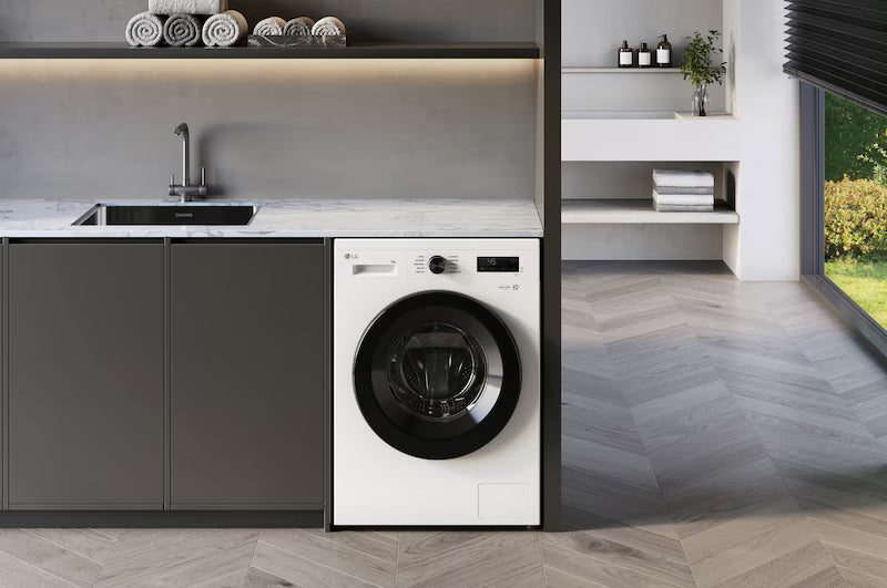 White washing machine integrated into a modern kitchen with gray cabinets.